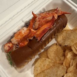A beautiful lobster roll with chips!