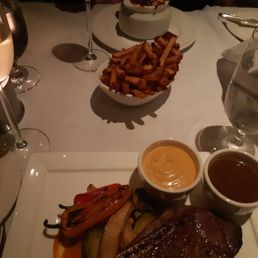 The dry aged strip steak with tacky sauces. Onion soup in the background. The dry aged strip steak with tacky sauces. Onion soup in the background.