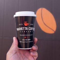 a hand holding a cup of coffee