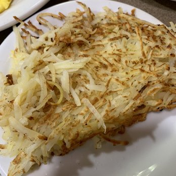Denny's - hashbrowns - A serving of hashbrowns made from shredded and grated potatoes, cooked until crispy, on a white plate. - Diners Near Me - Willowbrook, Illinois