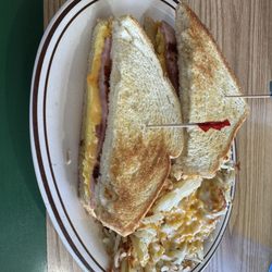 Ham, scrambled egg& cheese on sourdough toast with hash browns with cheese.