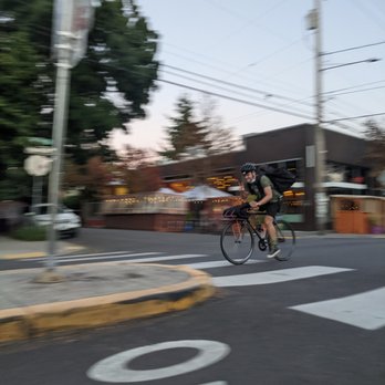 CCC PDX - a man riding a bike down a street - Food Delivery Services Near Me - Portland, Oregon