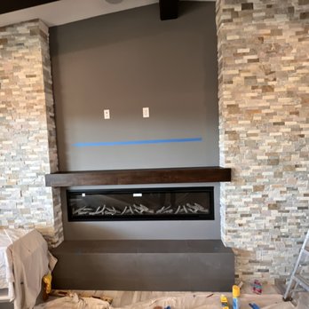 Ruiz Renovation - a living room with a fireplace and a ladder - Tiling Near Me Ruiz Renovation - a living room with a fireplace and a ladder - Tiling Near Me