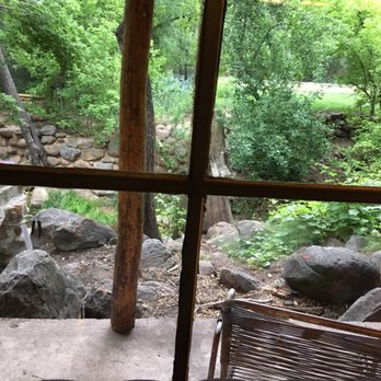 Christopher Creek Lodge - Porch and creek through main window of cabin. - Hotels Near Me - Payson, Arizona
