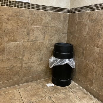 Enmarket - a trash can in a tiled bathroom - Gas Stations Near Me - Pooler, Georgia