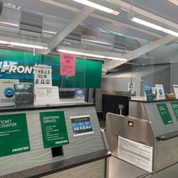 Frontier Airlines - Empty check in area with a lame sign that shows the time for check in