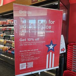 A red promotional sign at Target thanks customers for their service and offers 10% off two qualifying storewide purchases, valid from 10/29 to 11/11.