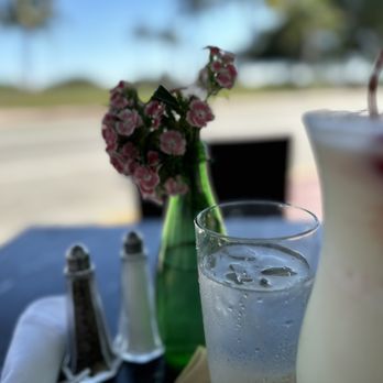 Cafe Americano - a glass of iced water and a vase of flowers - American Near Me - Miami Beach, Florida