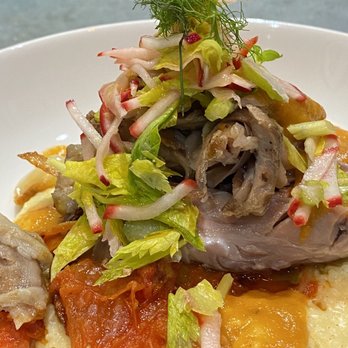 The Gilty Pig - Braised pork shank, blistered tomato and carrot confit, celery heart and radish salad over grits. - Food Trucks Near Me - Chicago, Illinois The Gilty Pig - Braised pork shank, blistered tomato and carrot confit, celery heart and radish salad over grits. - Food Trucks Near Me - Chicago, Illinois