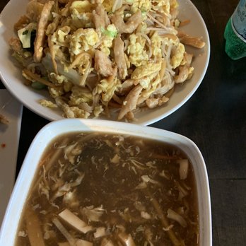 Tasty Dumplings - Hot and sour soup in front  Chicken rice noodle dish in back - Chinese Near Me - Lowell, Massachusetts