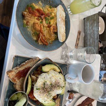 First Watch - Shrimp and Grits (L) skillet with eggs, potatoes and avocado (R). Bacon, sausage links and Pineapple Express. - Breakfast & Brunch Near Me - Pembroke Pines, Florida