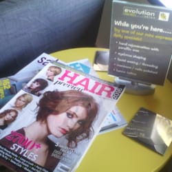 Evolution Salon - Magazines and a sign with some of the services they have.