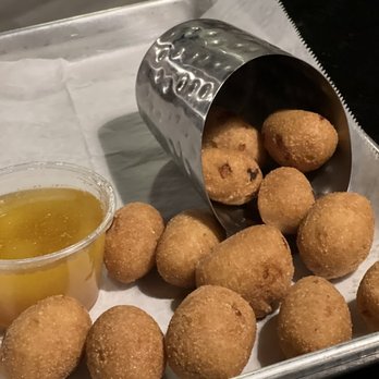 Riley's - a tray of doughnuts and a cup of sauce - American Near Me - Rincon, Georgia