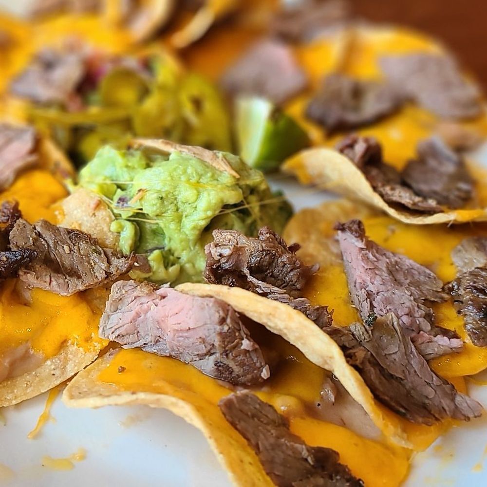 Mi Cocina - a plate of nachos with beef and guacamole - Mexican Near Me - Dallas, Texas Mi Cocina - a plate of nachos with beef and guacamole - Mexican Near Me - Dallas, Texas