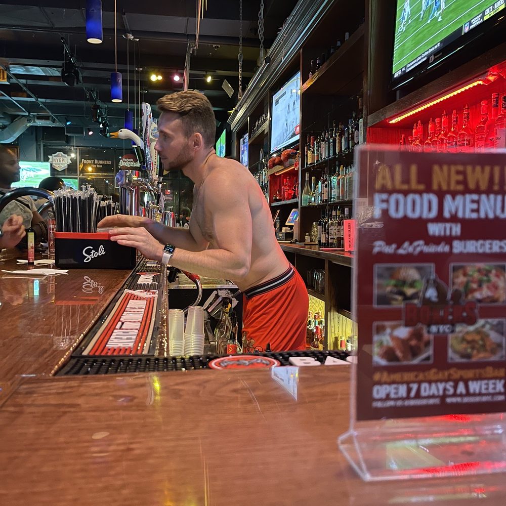 Boxers NYC - Chelsea - a shirtless man at a bar - Gay Bars Near Me - New York, New York