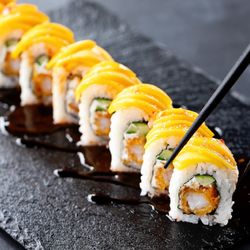 Rock N Roll Sushi - Shrimp tempura, cream cheese and cucumber inside, sliced mango outside, topped with sweet chili and eel sauce.