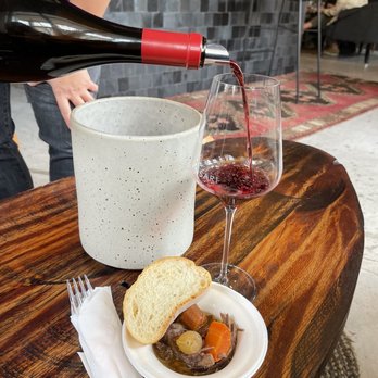 Baldassari Wine Lounge - a glass of wine being poured over a bowl of stew - Wine Tasting Room Near Me - Windsor, California