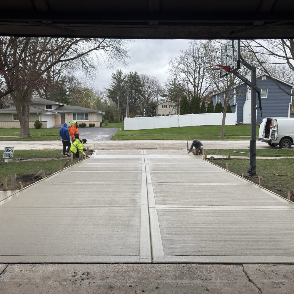 Concrete finishers completing a California finish on a new driveway Concrete finishers completing a California finish on a new driveway