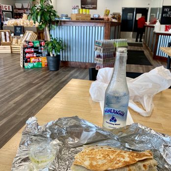 Kennedy's Meat - A view from my seat overlooking a veggie burrito and bottle of sparkling water. - Meat Shops Near Me - Escondido, California