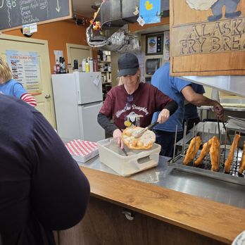 Klondike Doughboy - Sprinkling sugar on the Fry Bread. - Desserts Near Me - Skagway, Alaska