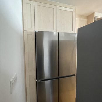 ATA Custom Cabinets - Broom / mop cabinet to the left of refrigerator with removable shelves. Storage on top of fridge. - Cabinetry Near Me - Canoga Park, California