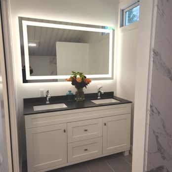 Mil-Spec Construction - Master bath remodeling with backlit mirror, solid surface counters, soft close drawers, chrome Delta faucets. - General Contractors Near Me