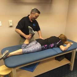 Maximum Wellness Rehabilitation - Dr. Jeff stretching one of our patients before she goes through her exercises.