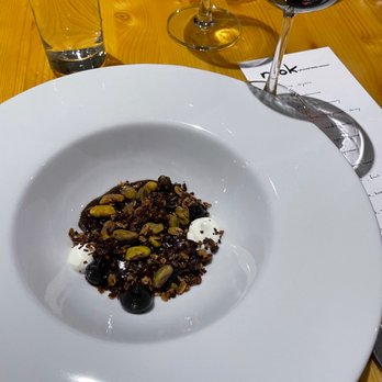 Nook - a plate of food on a table with wine glasses - New American Near Me - Madison, Wisconsin