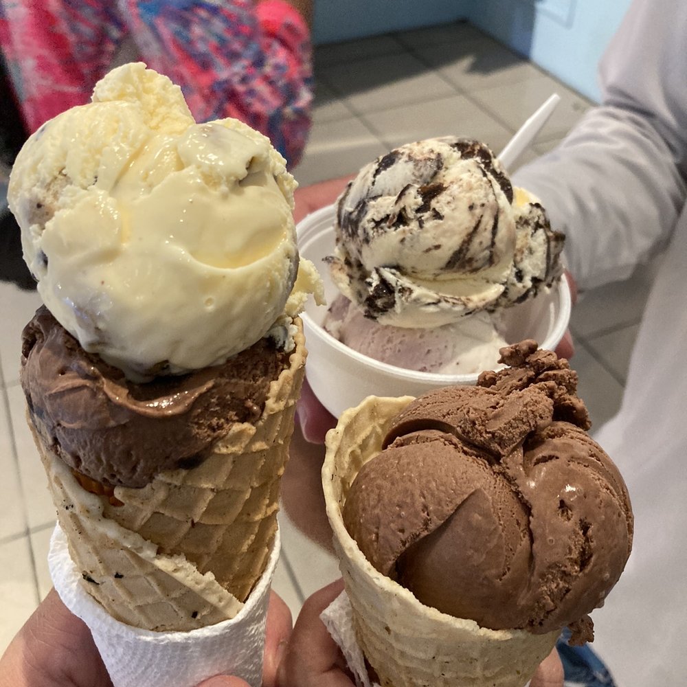 Waffle cone with cookie dough over fudge brownie, moose trail in a cup, and waffle cone with chocolate.