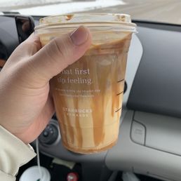 a hand holding a cup of iced coffee