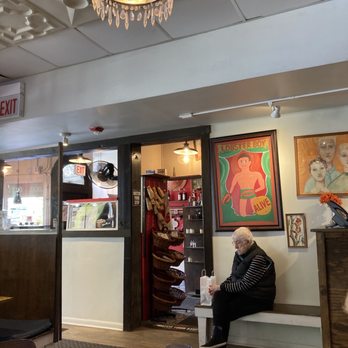 The Lucky Platter - a man sitting on a bench in a restaurant - New American Near Me - Evanston, Illinois The Lucky Platter - a man sitting on a bench in a restaurant - New American Near Me - Evanston, Illinois