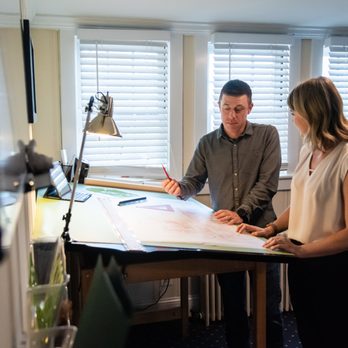 Outdoor Spaces - a man and a woman sitting at a desk - Landscape Architects or Designers Near Me - Leesburg, Virginia Outdoor Spaces - a man and a woman sitting at a desk - Landscape Architects or Designers Near Me - Leesburg, Virginia