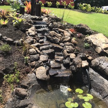 The Yard Guy - Pondless/ pond hybrid waterfall (as well as sprinklers, sod and beds in background) - Landscaping Near Me - Kailua, Hawaii The Yard Guy - Pondless/ pond hybrid waterfall (as well as sprinklers, sod and beds in background) - Landscaping Near Me - Kailua, Hawaii
