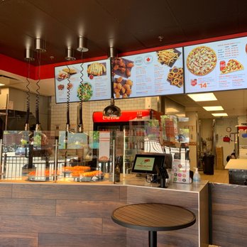 Pizza Pizza - a restaurant counter with a pizza menu on the wall - Pizza Near Me - New Westminster, British Columbia