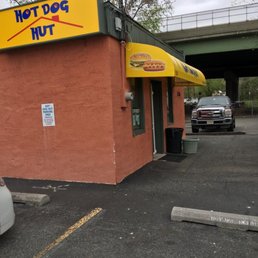 a car parked in front of a hot dog hut a car parked in front of a hot dog hut
