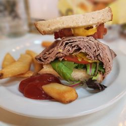 Roast beef and bacon on sourdough and a side of friea.