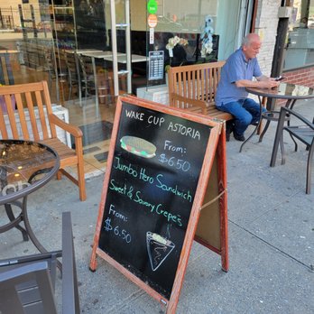 Wake Cup Astoria - a man sitting at a table outside - Cafes Near Me - New York, New York Wake Cup Astoria - a man sitting at a table outside - Cafes Near Me - New York, New York