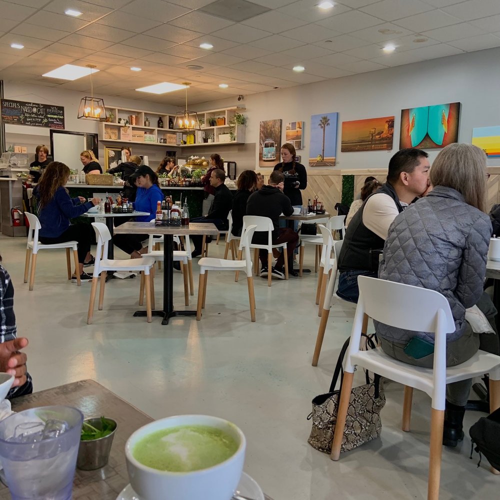 Naked Cafe - a woman sitting at a table with a bowl of soup in front of her - Breakfast & Brunch Near Me - Encinitas, California Naked Cafe - a woman sitting at a table with a bowl of soup in front of her - Breakfast & Brunch Near Me - Encinitas, California