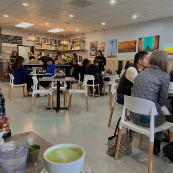 Naked Cafe - a woman sitting at a table with a bowl of soup in front of her - Breakfast & Brunch Near Me - Encinitas, California Naked Cafe - a woman sitting at a table with a bowl of soup in front of her - Breakfast & Brunch Near Me - Encinitas, California