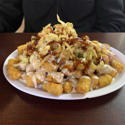 Salty Farmer - BBQ Shoe. Layers of grilled cheese sandwich topped with pulled pork, pickles, onion straws, tater tots and cheese sauce.