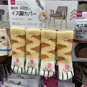 Daiso - Four pairs of cartoon-style animal socks with tiger stripes and paw prints are displayed at Daiso, a Japanese-inspired retail store. - Discount Store Near Me - Rancho Cucamonga, California