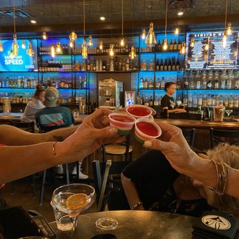 Rabbit Hole Neighborhood Bar - a group of people toasting - Bars Near Me - Leander, Texas Rabbit Hole Neighborhood Bar - a group of people toasting - Bars Near Me - Leander, Texas