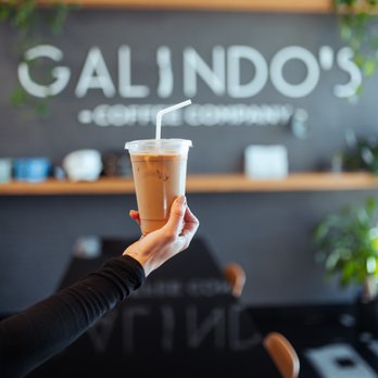 Galindo's Coffee + Elixirs - a hand holding a cup of coffee - Coffee & Tea Near Me - Conroe, Texas
