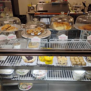 Gypsy Kitchen - Baked goods and bites on the case - A glass bakery display case contains assorted baked goods, snacks, and desserts, with handwritten labels, at Gypsy Kitchen in Lockport, NY. - Coffee & Tea Near Me - Lockport, New York