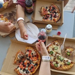 a group of people eating pizza a group of people eating pizza