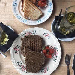 Tartine - Tartini met geitenkaas, spek en rucola. (Bruin brood)  €7,50. Tartini Hawaï met kip, ananas en kaas. (Wit brood) €7,50.