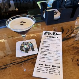 a cocktail and a menu on a table