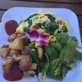 Photo of Barefoot Beach Cafe - Honolulu, HI, United States. Omelet with greens and roasted potatoes.