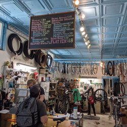 Blue City Cycles - Photo of the interior of the shop behind the counter, with bike mechanics working on bike repairs
