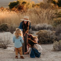 Sheenagal Photography - Backlit image of mother interacting with her children in some tall grass
